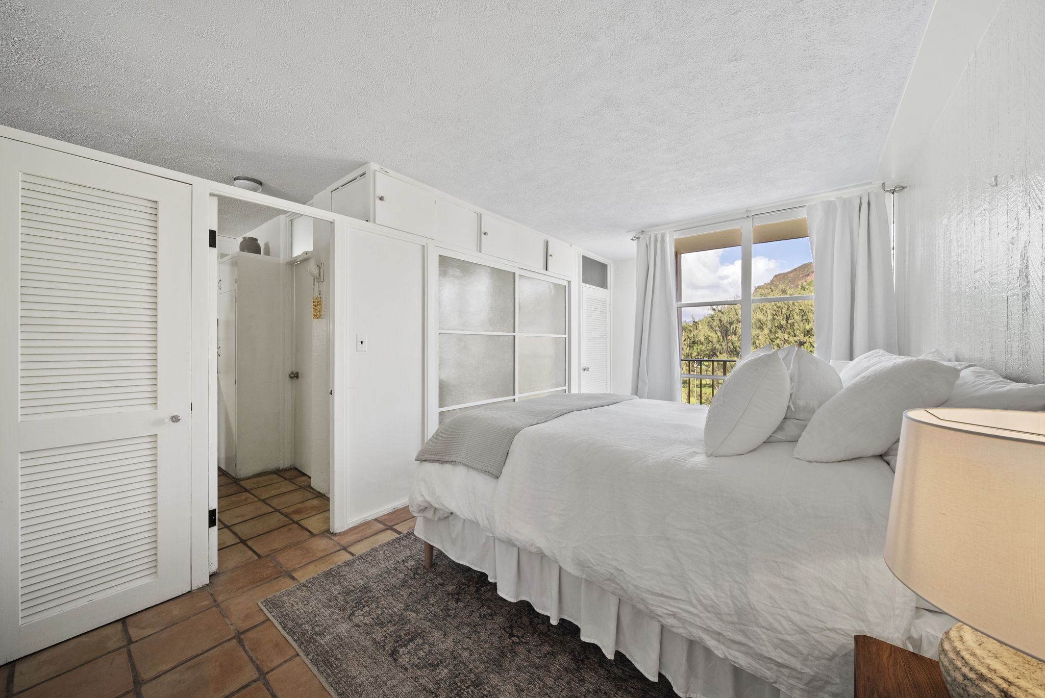 Peaceful white bedroom with Diamond Head visible through the window