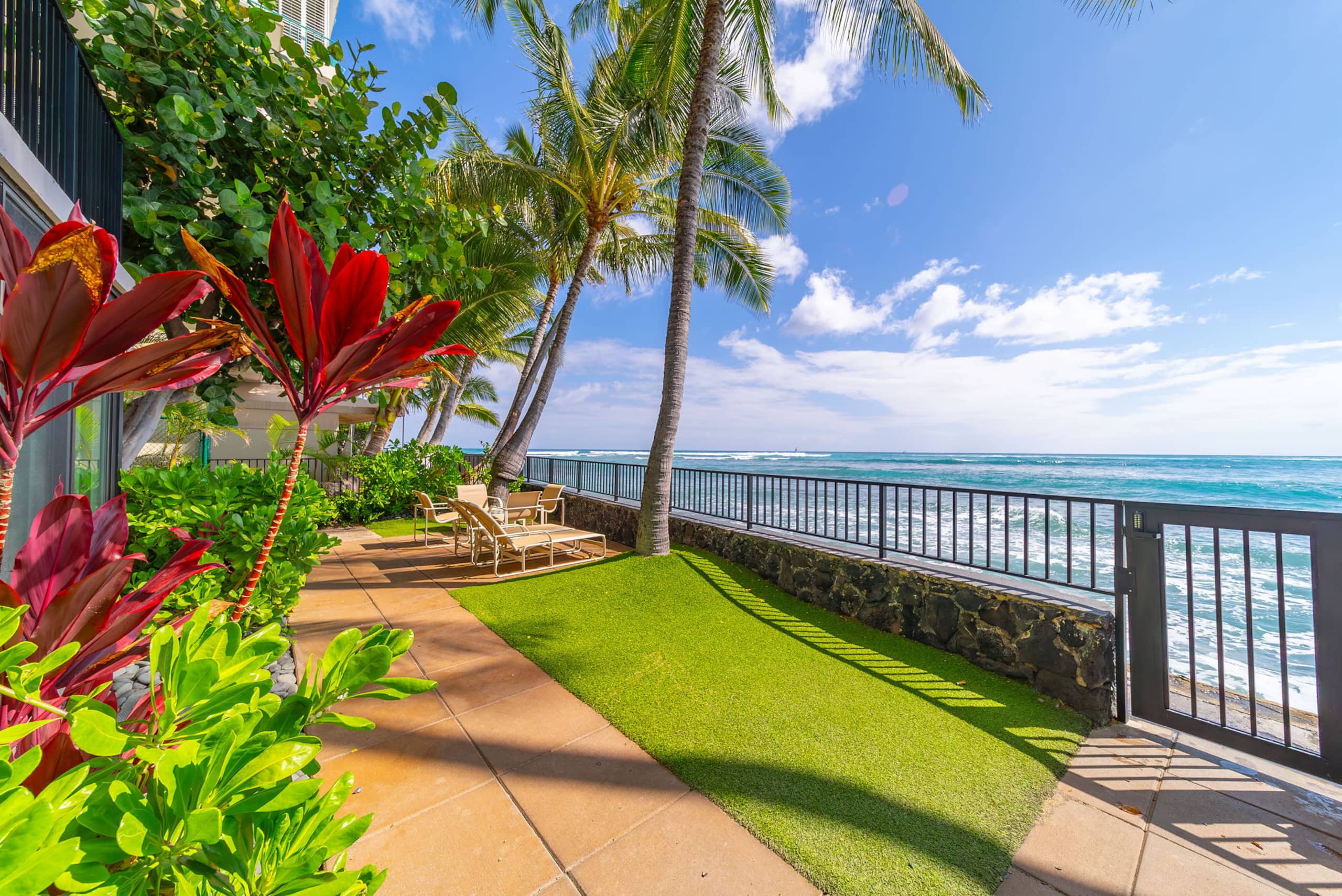 Sunny oceanfront lawn and tropical garden beside the seawall
