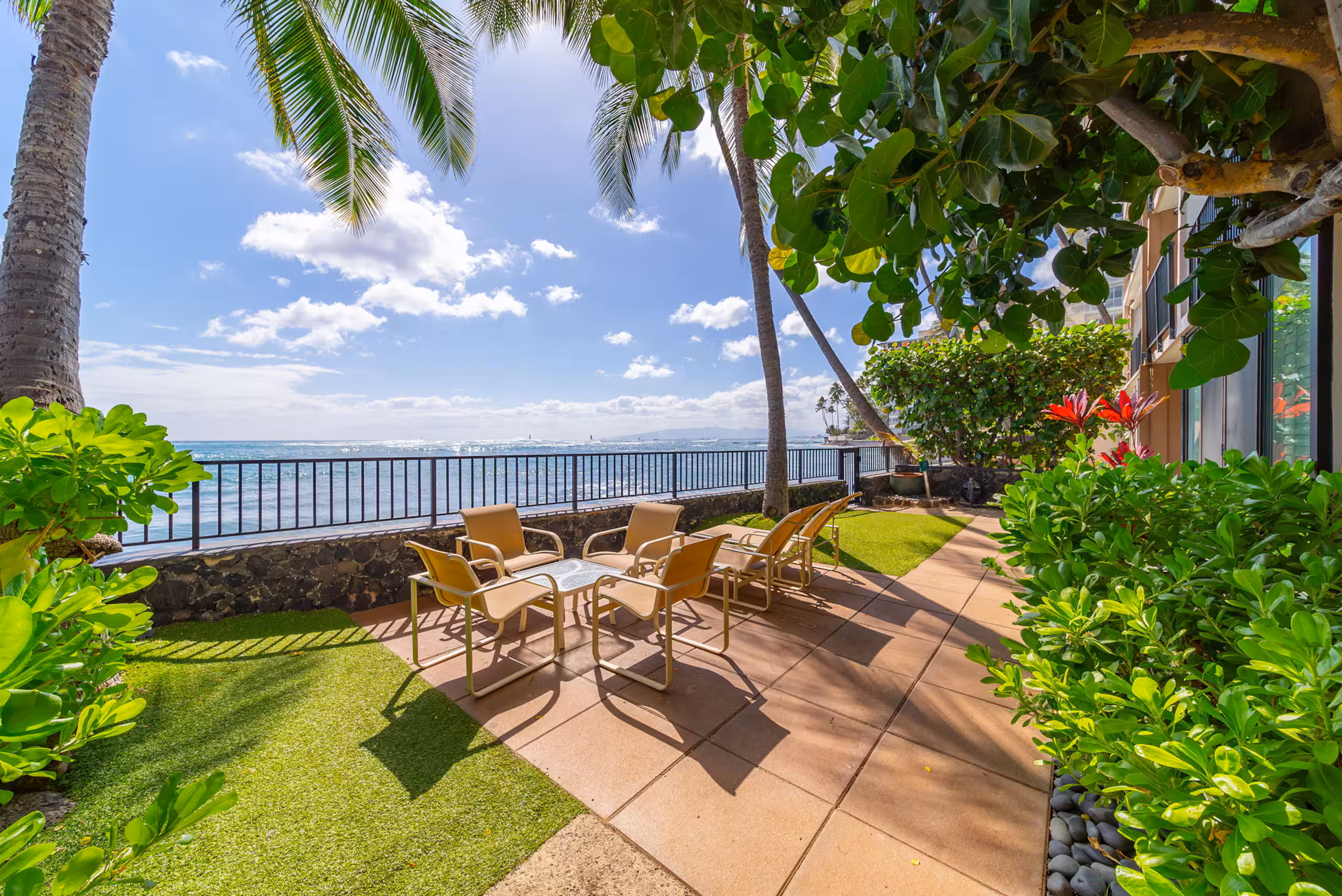 Oceanfront garden patio with palms and seating